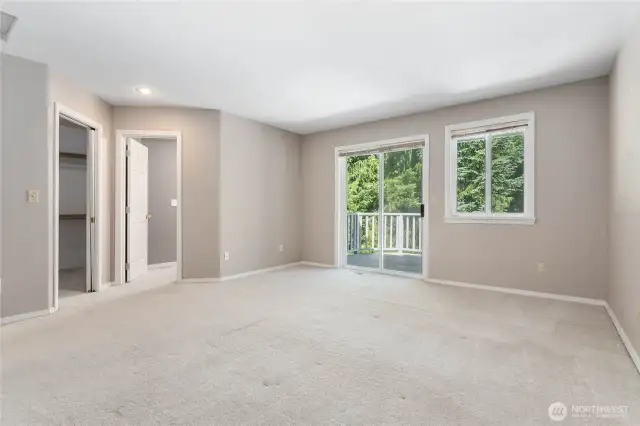Bright and airy primary bedroom with sliding doors that open to a private deck space.