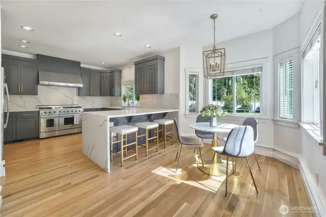 There is plenty of space to entertain in this large, updated kitchen that feature new cabinetry, quartz countertops and backsplash, refinished hardwood floors, 48" gas stove, and updated light fixtures.
