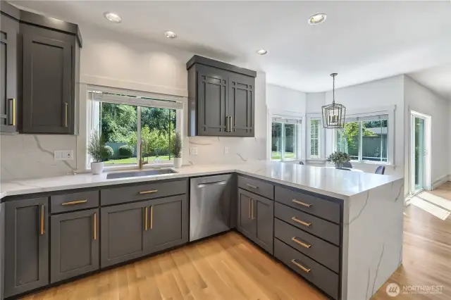There is plenty of space to entertain in this large, updated kitchen that feature new cabinetry, quartz countertops and backsplash, refinished hardwood floors, 48" gas stove, and updated light fixtures.