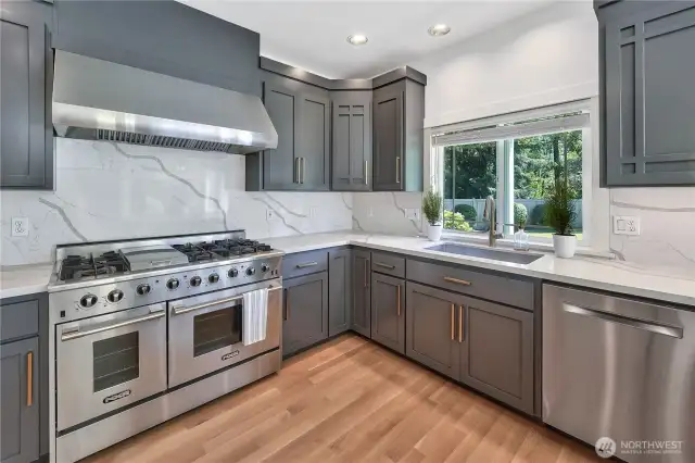There is plenty of space to entertain in this large, updated kitchen that feature new cabinetry, quartz countertops and backsplash, refinished hardwood floors, 48" gas stove, and updated light fixtures.