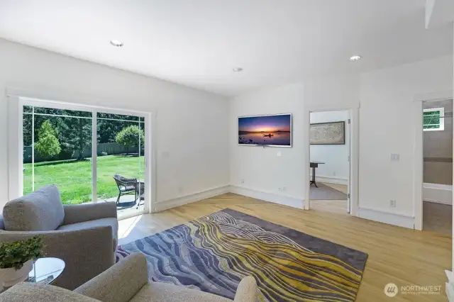 This secondary living space provides additional space off the kitchen. Sliding door leads to the large, private back yard. This also shows the main floor den and full bath.