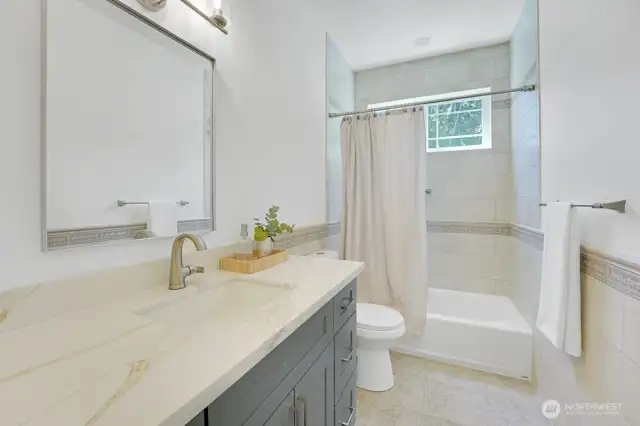 Next door to the main floor den is this full bath on the main floor with new vanity, countertop, mirror and light fixture.