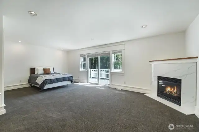 The primary suite features a private balcony, gas fireplace with new quartz slab facing, and an abundance of space.