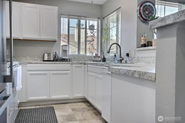 The kitchen is updated w/ laminate counters, raised panel cabinets and laminate tile flooring. Stainless appliance complement the kitchen's design.