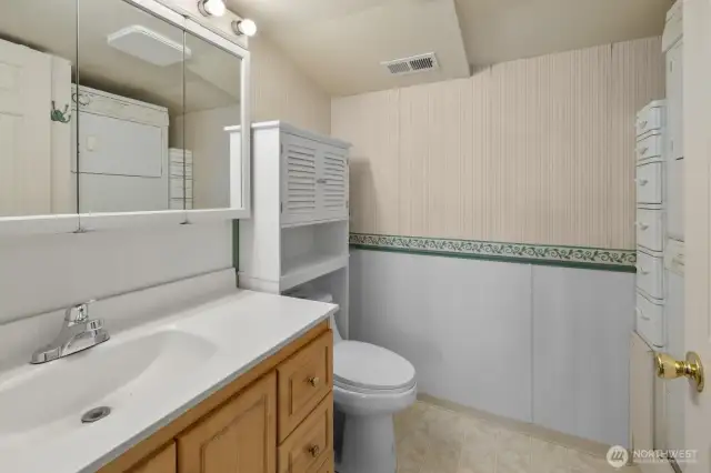 Bathroom in basement with shower, laundry, toilet and sink