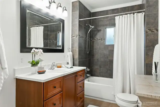 The spa-like bath is remodeled with tiles tub surround and quartz vanity.