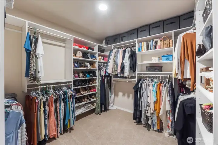 A generous walk-in closet with a fully built-out organization system, offering ample hanging space, shelving, and storage. This well-designed layout keeps everything tidy and easy to access.
