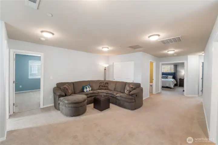 A spacious upstairs bonus room offering a comfortable second living space, perfect for movie nights, a play area, or a homework zone. Its central location provides easy access to all upstairs bedrooms, giving the entire floor a practical, relaxed layout.
