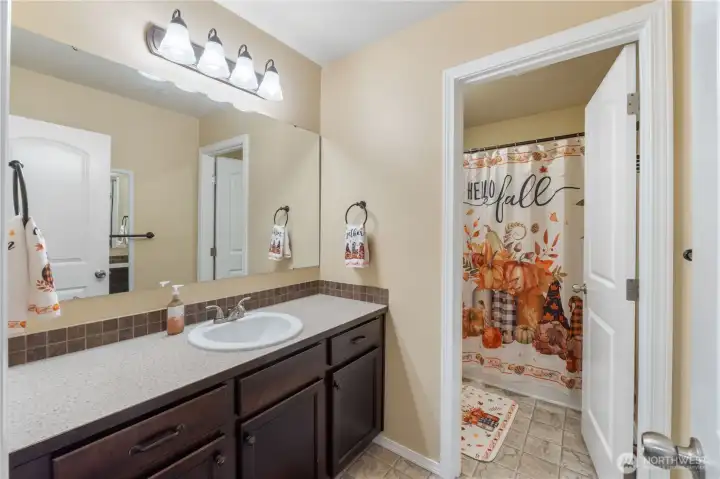 A well-kept full bathroom with an extended vanity, framed lighting, and a separate shower and toilet area for convenience. Neutral finishes make it easy for buyers to imagine adding their own style.