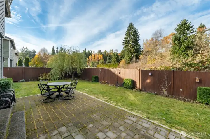 A wide paver patio sits just off the back of the home, blending lawn and outdoor living space. It’s ideal for BBQs, morning coffee, or simply taking in the treed backdrop.