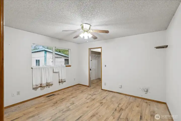 Primary bedroom with view to closet and bath
