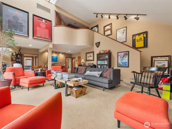 The open floor design brings in natural light. Stairs lead to the two private suites