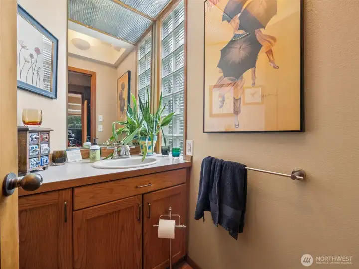 A half bath is located discreetly off the entry, just past a wall of storage