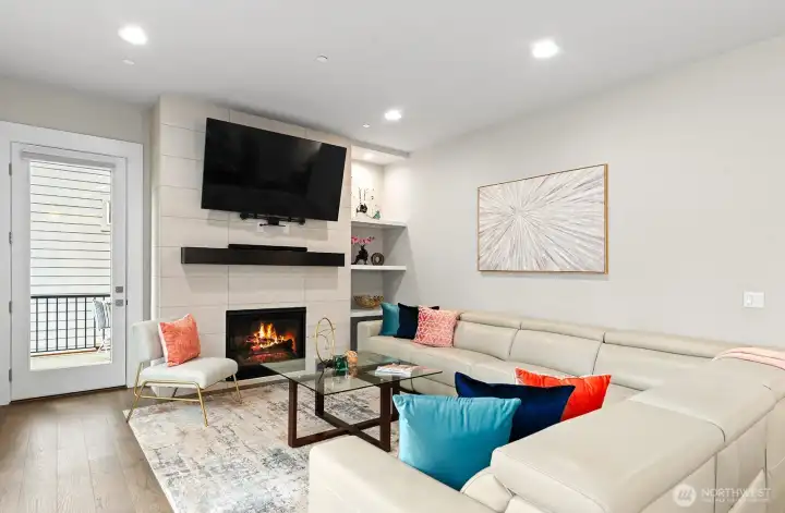 Spacious family room with cozy fireplace, contemporary mantel and built-in shelving. Pre-wired for speaker system. Glass door provides access to the covered deck.