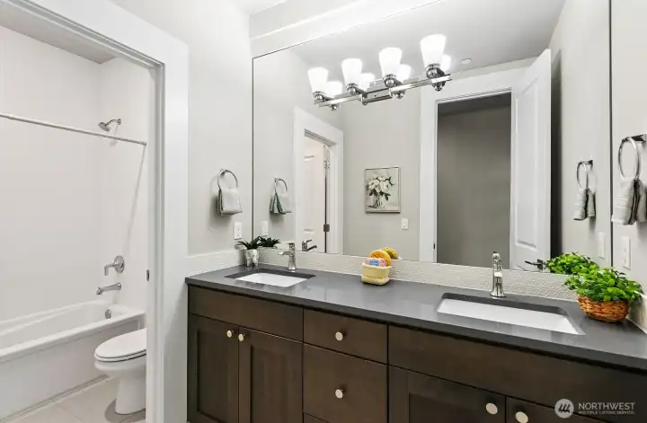 Fulll bath on the upper level with double vanities and custom ceramic tile.