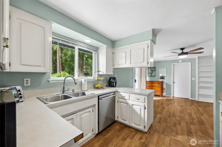 Kitchen is conveniently located between dining room and an extra living space. Closed door leads to utility room and garage.