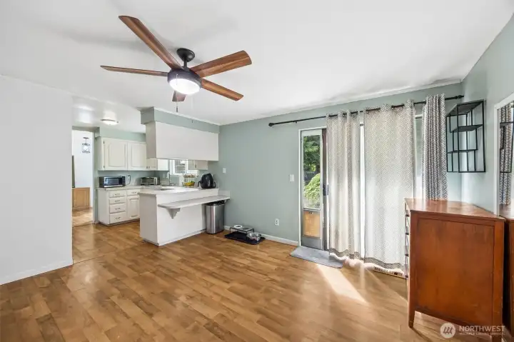 From the corner of the extra living space, showing the kitchen and slider to yard.