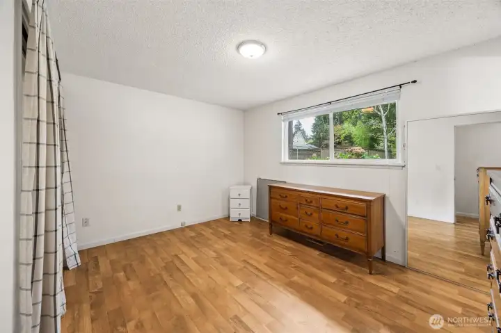 Primary bedroom with laminate flooring, has attached en suite bathroom.