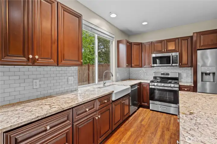 Chef's kitchen featuring a premium farm sink, spacious pantry for ultimate storage, and newly updated stainless appliances Chef's kitchen featuring a premium farm sink, spacious pantry for ultimate storage, and newly updated stainless appliances