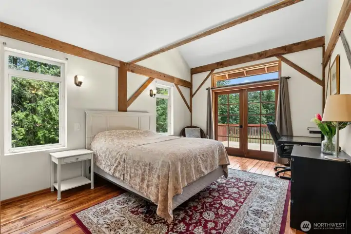 . Spacious primary bedroom with French doors opening directly onto the deck
