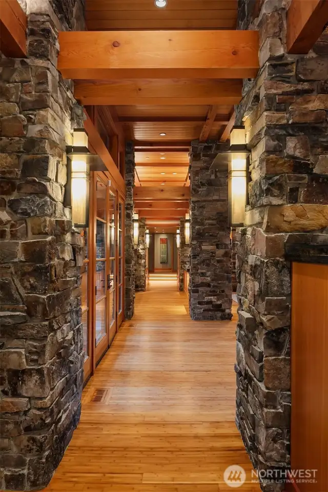 The beams, stone, and custom lighting are anchored with the warm bamboo floors.