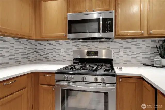 Stainless steel gas range and matching built-in microwave.