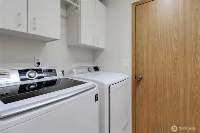 Laundry room with cabinets above for convenience with both washer and dryer included, plus direct access to the garage for everyday ease.