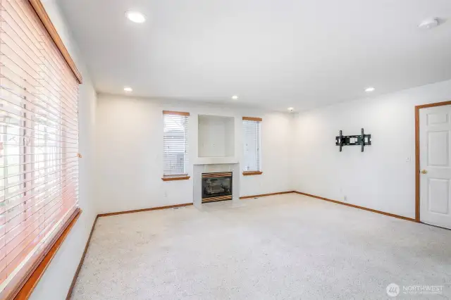 Main living room with gas fireplace and can lighting.