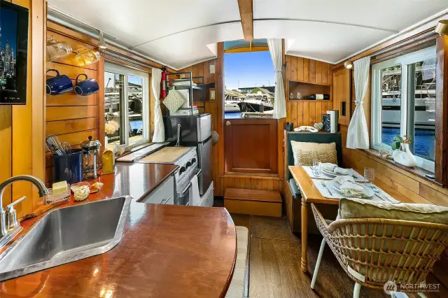 From the saloon, enjoy a seamless blend of galley and dining space, where double-pane windows capture Lake Union’s ever-changing light and the craftsmanship of the Meranti Hydrotek hull underfoot ensures lasting beauty.