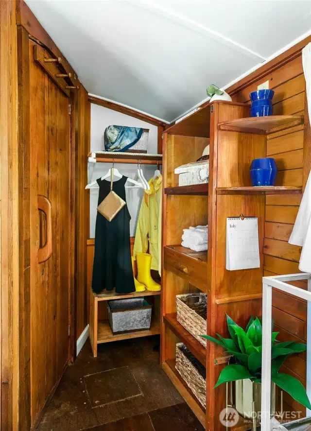 The companionway leads to the captain’s quarters, with efficient built-in shelving and hanging storage crafted from warm wood — keeping essentials organized without sacrificing charm.