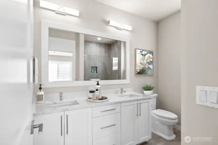 Primary bathroom with thick slab quartz countertops, double undermount sinks and a large fully tiled shower.
