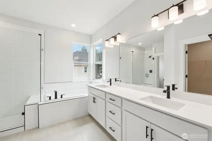 Spa Inspired primary bath includes 12x24 tile floors, quartz counters, black hardware, plumbing and lighting.  Soft close cabinets and drawers.  Huge soaking tub and frameless tiled walk-in shower.  A dream walk -in closet and separate water closet for privacy.  Pic of similar home, colors and materials may vary
