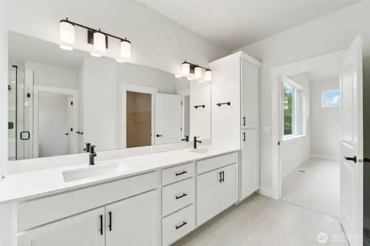 Dual sinks, quartz counters and black plumbing and hardware.  Pic of similar home, colors and materials may vary