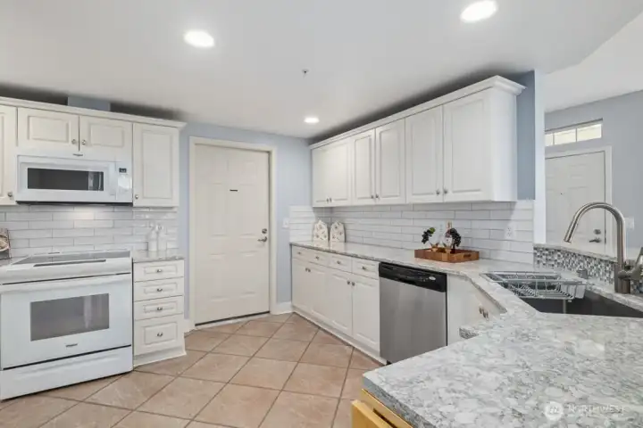 New slab quartz countertops and white subway tile backsplash