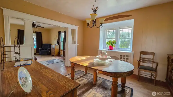 The perfect flow for your next gathering! Take a look at the view from the dining room into the main living space. We absolutely love how the classic built-in pillars define the spaces while keeping that highly sought-after open-concept feel. Notice the beautifully built-in window console, too—perfect for your plants or extra storage!