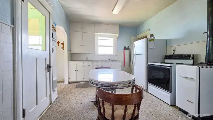 Step back in time in the best way possible! Welcome to the heart of the home. If you love authentic vintage charm, this classic farmhouse kitchen is an absolute dream. From the crisp white floor-to-ceiling cabinets to the perfect spot for a retro chrome diner table, this space is just waiting for your 1950s-inspired touches!