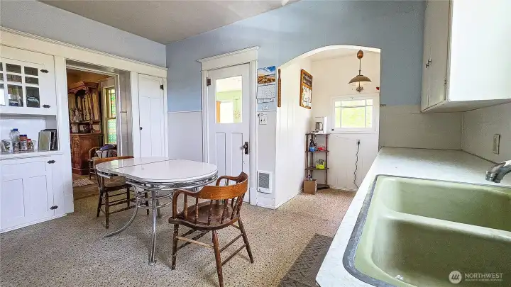 Spacious kitchen featuring a double sink, built-in hutch, eat-in dining space, and an adjacent walk-in pantry room.