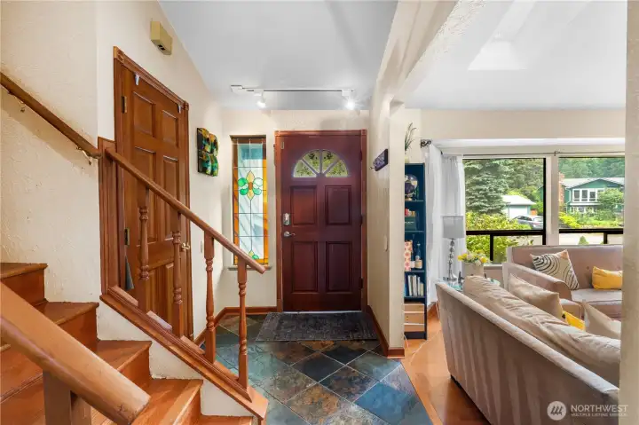 Inviting foyer with hardwood staircase and custom stained-glass accents. Radiant heated slate entry.