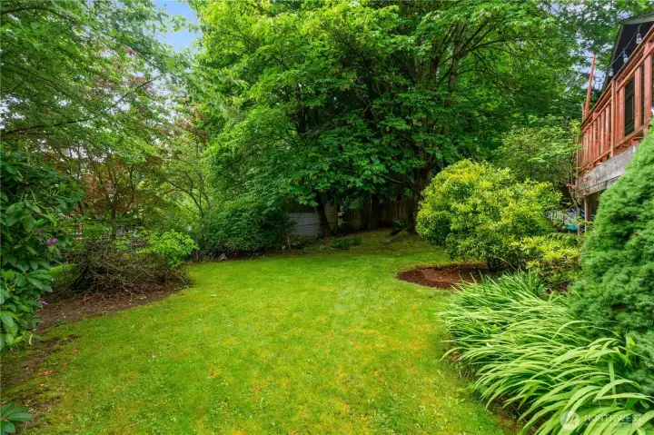 Expansive backyard with mature landscaping and plenty  of room to relax, garden, or play.