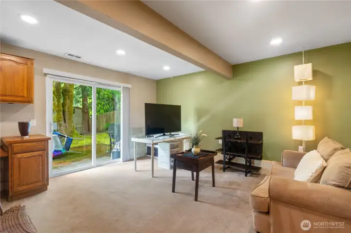 Lower-level indoor-outdoor living with a sliding glass door leading directly to the backyard.