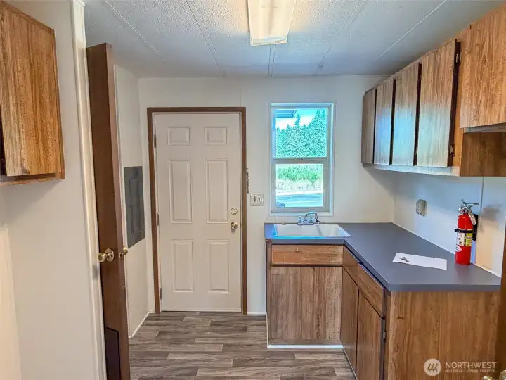 Steppin out of the Family room to the Utility with deep sink and lots of counter space and storage. Full bath on the left