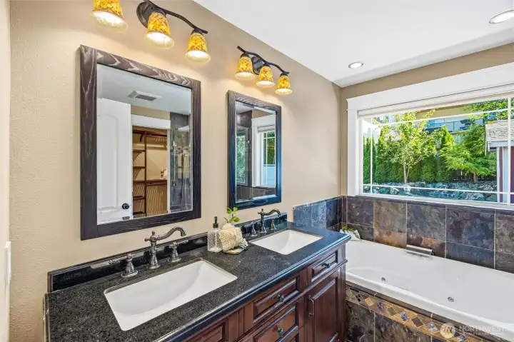 Updated primary bathroom with double vanity and jetted tub and glass shower. Updated primary bathroom with double vanity and jetted tub and glass shower.