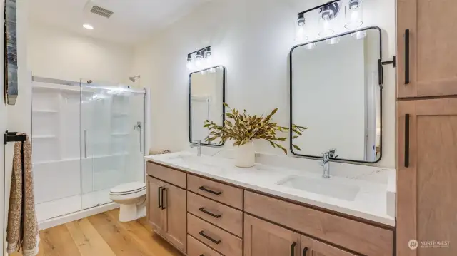 The primary bath features quartz countertops, double-sink vanity, and oversized walk-in shower.