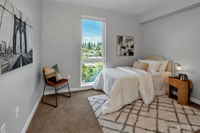 The second bedroom, with large windows offering mountain views, provides ample closet space.