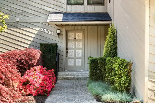 Front walkway highlighted by colorful Azaleas bushes, Japanese maples, boxwoods and ornamental grasses.