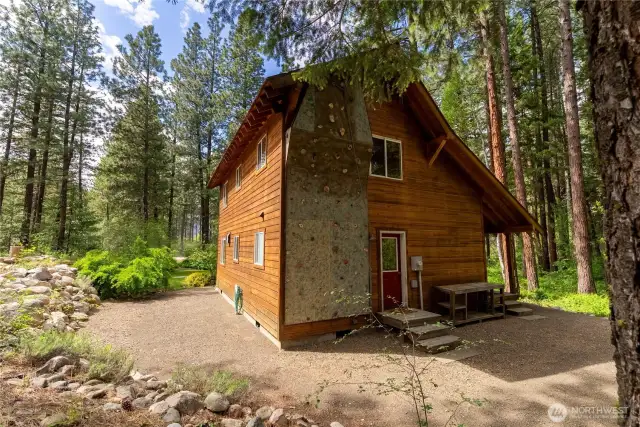 Climbing wall located on the private, forested side of the house for shade, privacy, and a true outdoor recreation vibe. An ideal feature for families, training, or fun weekend challenges—rarely found in residential properties.