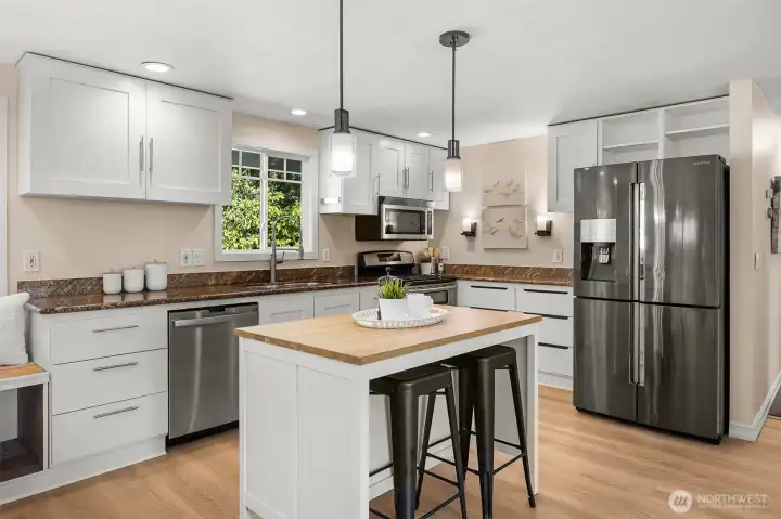 Granite counters and stainless steel appliances highlight this inviting kitchen.