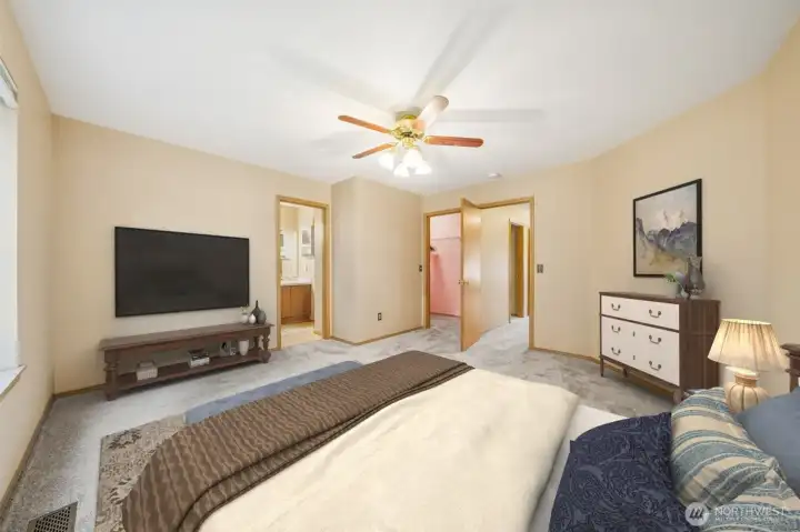 Primary bedroom with entrance to primary bath and walk-in closet. (virtually staged)