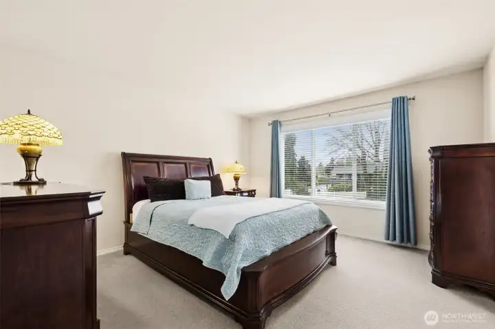 The generously sized primary suite boasts plenty of space for oversized furniture and is filled with natural light from a large picture window overlooking the backyard.