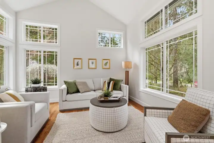 Floor to ceiling windows and soaring vaulted ceilings create a bright, light-filled living room bringing the outdoors in.